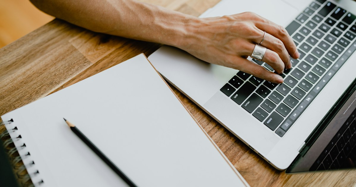 Person typing on a laptop writing a post